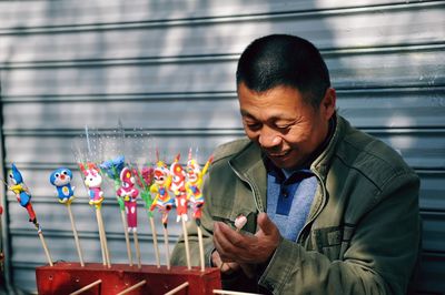 Close-up of smiling man holding mobile phone