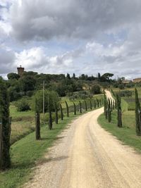 Road amidst field against sky