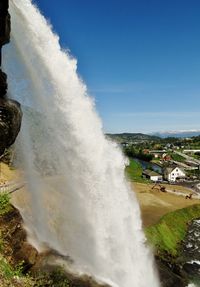 High angle view of waves breaking against clear sky