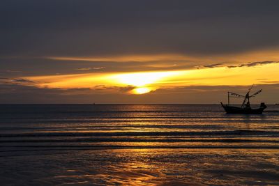 Silhouette sailboat on sea against sky during sunset