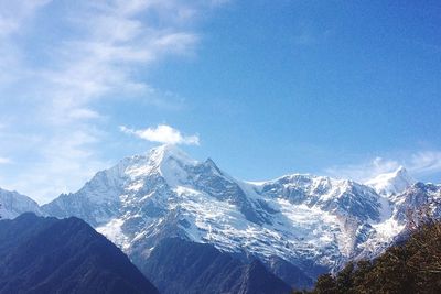 Scenic view of snowcapped mountains against blue sky