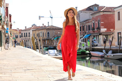 Young woman standing against built structure