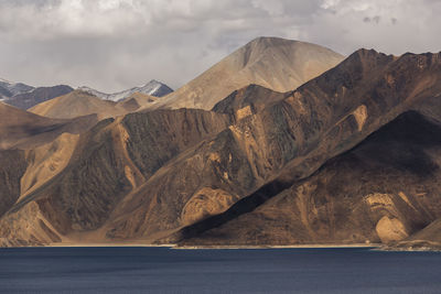 Scenic view of mountain range against cloudy sky