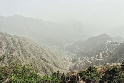 Scenic view of mountains against cloudy sky