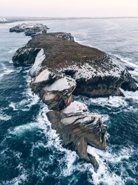 Scenic view of rocks in sea against sky