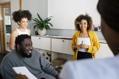 Happy male and female business professional discussing during meeting at office