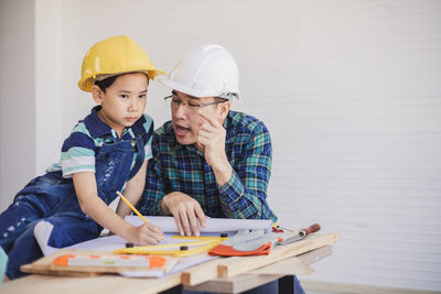 Engineer assisting son in making drawing