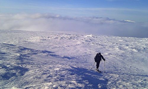 Rear view of man walking on snowcapped mountain