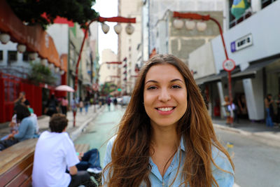 Portrait of smiling young woman in city