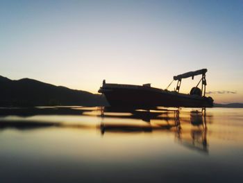 Silhouette boat in sea against clear sky