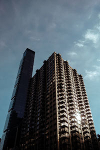 Low angle view of modern building against cloudy sky