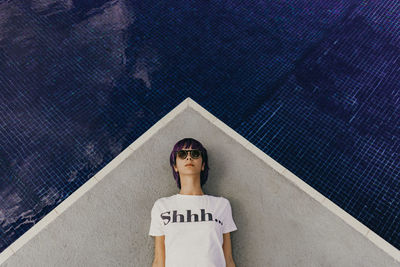 High angle view of woman lying by swimming pool