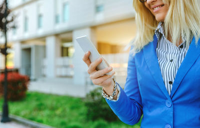 Close-up of young woman using mobile phone outdoors