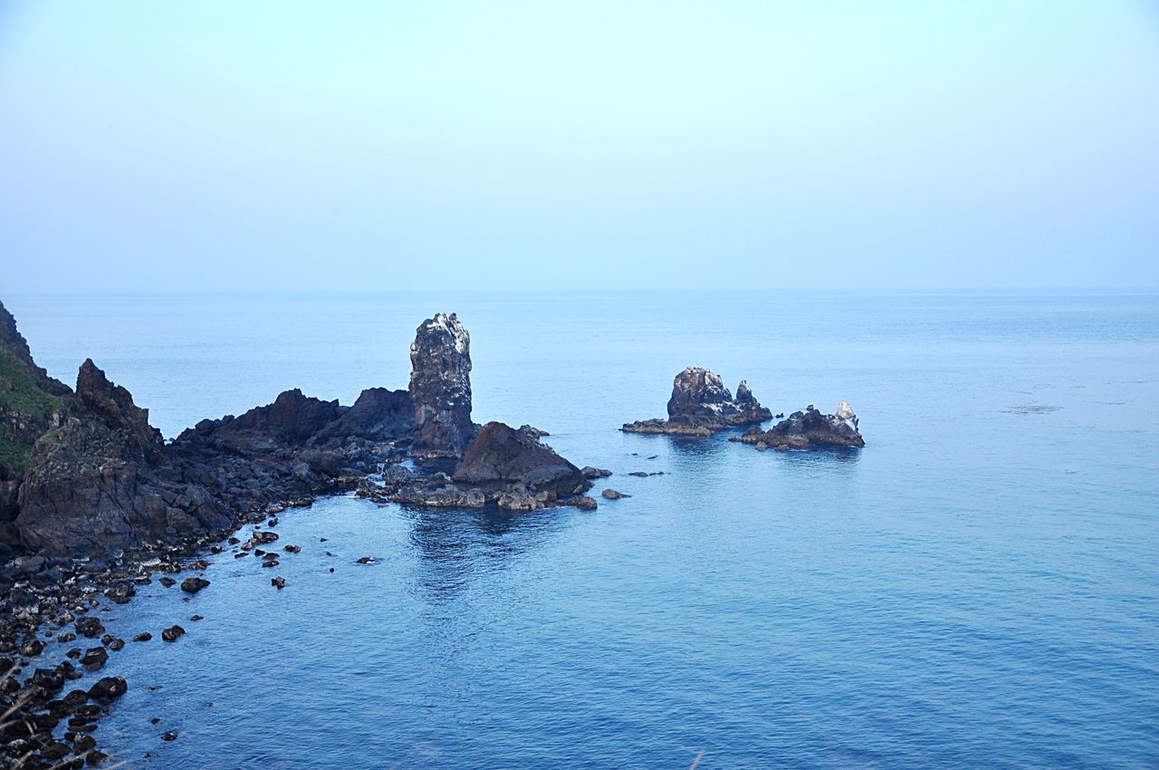 sea, water, horizon over water, clear sky, copy space, tranquility, tranquil scene, waterfront, scenics, rock - object, blue, beauty in nature, nature, rock formation, built structure, architecture, building exterior, sky, idyllic, cliff