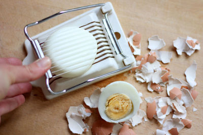 High angle view of boiled eggs and egg cutting tool on table
