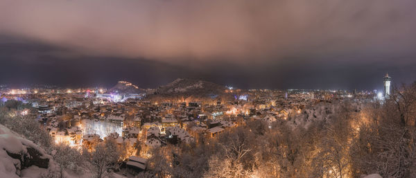 High angle view of illuminated city against sky at night