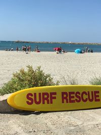 People on beach against clear sky