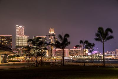 Illuminated buildings against sky at night