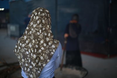 Rear view of women walking on street in city