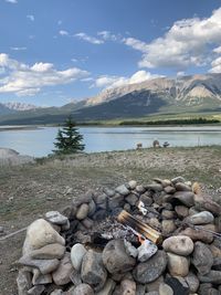 Stack of stones by lake against sky