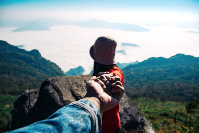 Woman holding hand of man on mountain