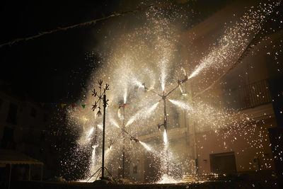 Low angle view of firework display at night