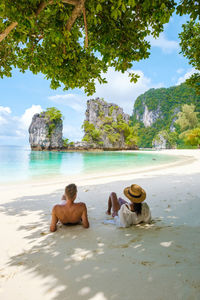 Rear view of woman sitting on beach