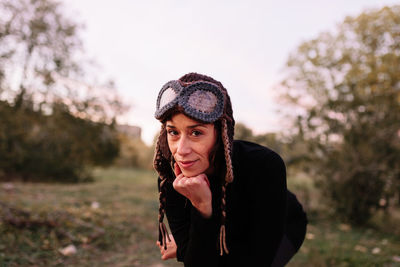 Portrait of young woman looking away while standing on field