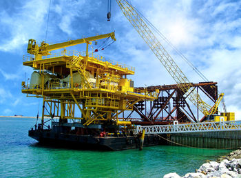 Low angle view of crane against sky