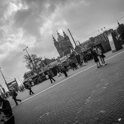 People in city against cloudy sky