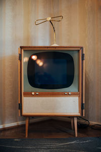 Retro television set against wall at home