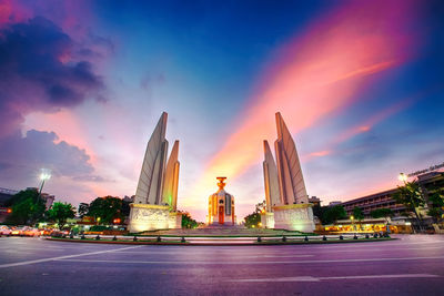 Statue of illuminated temple against sky at sunset