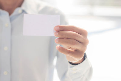 Close-up of businessman holding business card