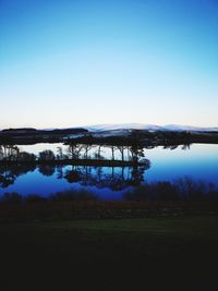 Scenic view of lake against clear blue sky