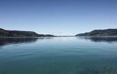 Scenic view of lake against clear blue sky