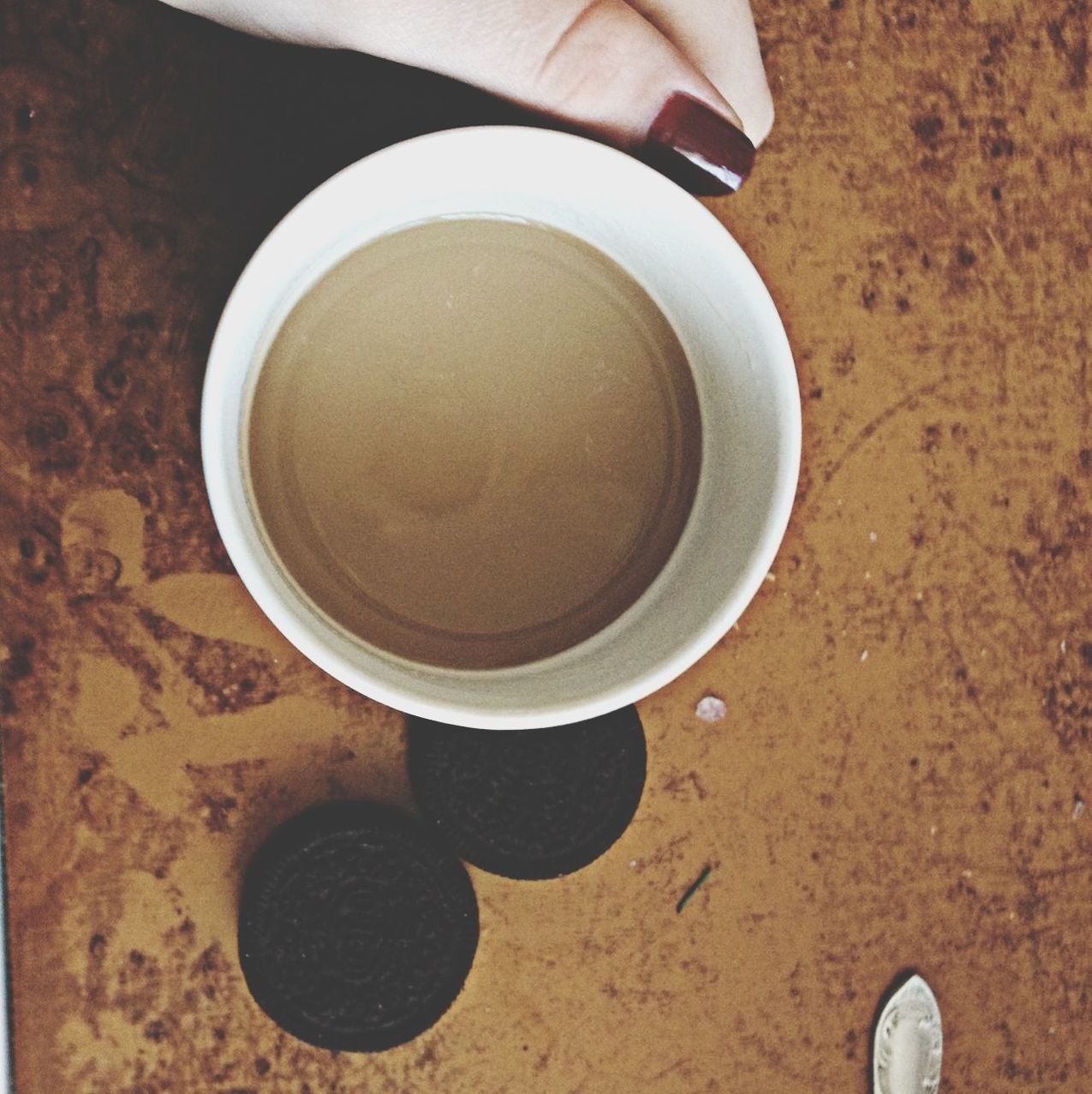 low section, high angle view, person, coffee cup, directly above, drink, indoors, shoe, food and drink, part of, personal perspective, coffee - drink, cup, still life, refreshment, close-up, overhead view