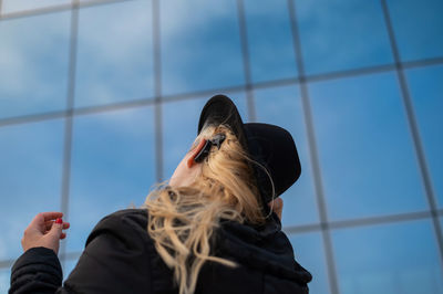 Low angle view of woman looking through window