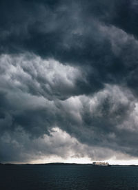 Scenic view of sea against storm clouds