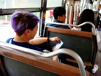 Woman reading book while sitting on seat