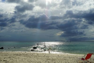 Scenic view of beach against cloudy sky