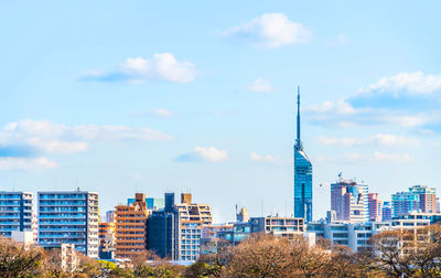 Buildings in city against cloudy sky