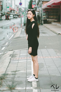Full length of woman standing on footpath