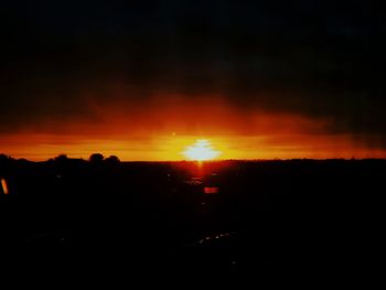 Scenic view of silhouette landscape against orange sky