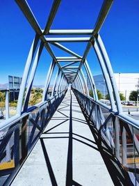 View of footbridge against clear blue sky