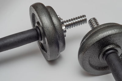 Close-up of dumbbells against white background