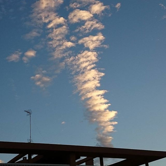 low angle view, blue, built structure, sky, architecture, building exterior, high section, cloud - sky, cloud, outdoors, no people, day, building, nature, street light, copy space, vapor trail, connection, roof, cloudy