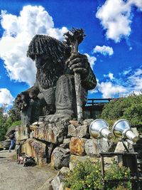 Statue by tree against sky