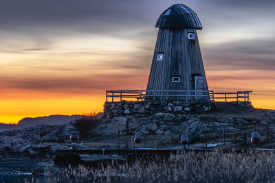 The old windmill in lycke on the swedish west coast against a beautifully colored sky during sunset.