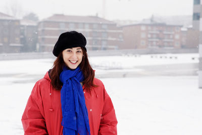 Portrait of smiling young woman at city in winter