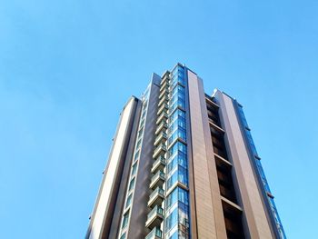 Low angle view of skyscraper against clear blue sky